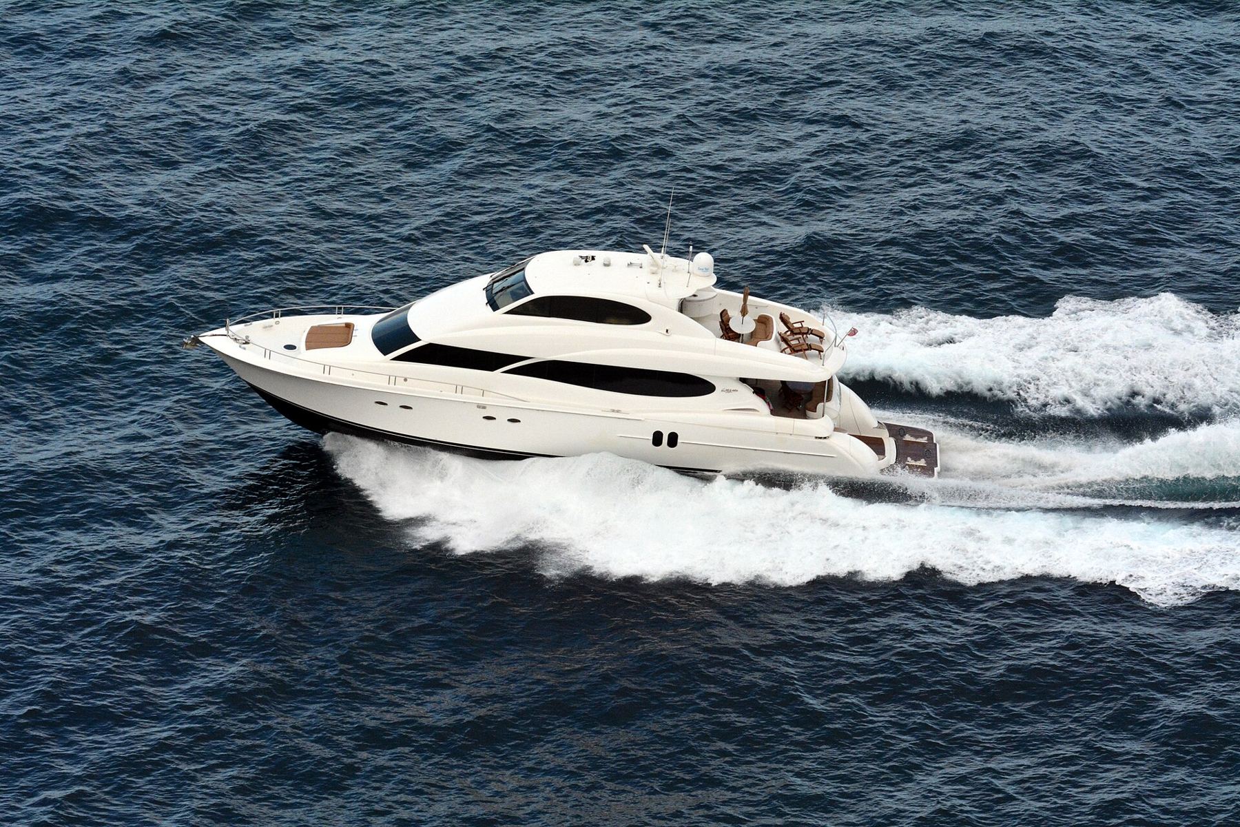 Un crucero blanco navegando a velocidad, dejando una estela de espuma